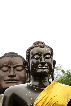 Dark Brown Budha statue with another Budha looking over his shoulderの写真素材