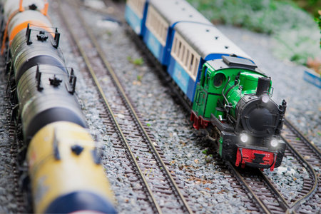 Set of red electric model railway locomotive and layout with a station and whole scene with...