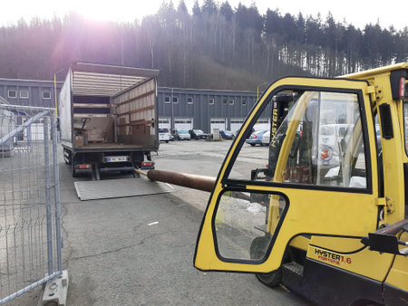 Vsetin Czech Rep, 03-11-21, Forklift unloads a huge and long metal pipe from a lorry.
