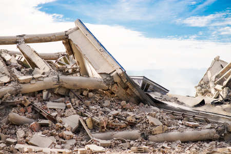 collapsed concrete industrial multilevel building. Disaster scene full of debris, dust and damaged houseの写真素材