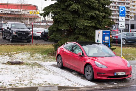 Roznov Czech Republic November 20th 2022 - Tesla model S car being charged with a yellow mussle car in backgroundのeditorial素材
