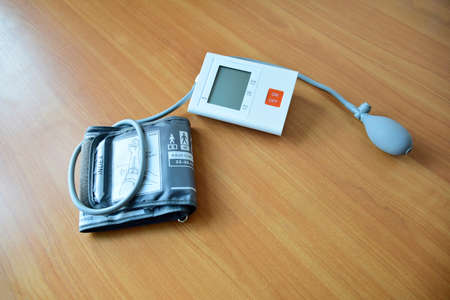 Blood pressure monitor digital type on wooden background. Classified as general medical instrumentsの写真素材