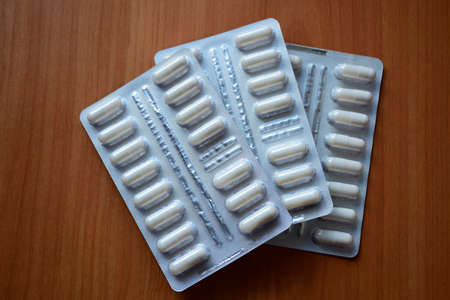 Set tablets in a white pack blister pack. Close up on wooden background.の写真素材