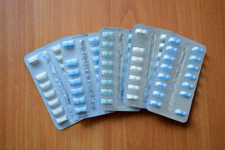 Set of various tablets in a blue pack blister pack. Healthcare and medical concept. Close up on wooden background.の写真素材