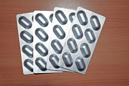 Pile of tablets pill in blister packaging to protect medicine from light. Silver aluminum foil blister pack. Pharmaceutical industry. Pharmacy products. Drug recall and withdrawal from market conceptの写真素材