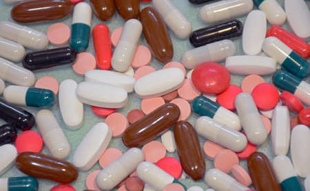 Different colorful many pills and capsules in abstract style. Healthy background. Health care, medical concept. Blue background.の写真素材