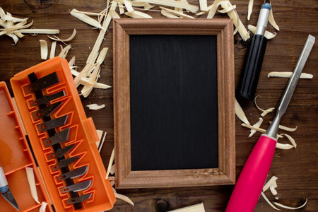 Chalk board lies next to a set for cutting wood and sawdust.