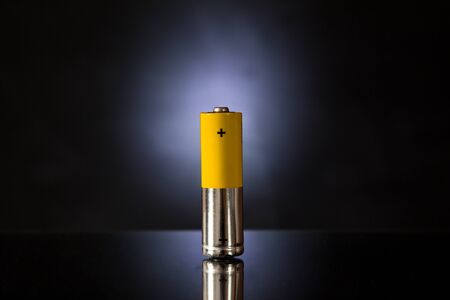 One yellow-silver battery with a black backlitの写真素材