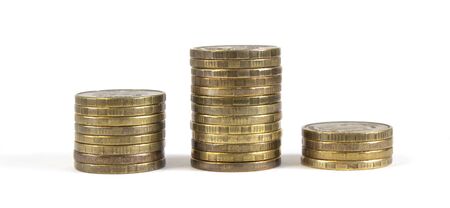 Three columns of coins laid out as a tribune for awarding winners on a white isolated background.の写真素材