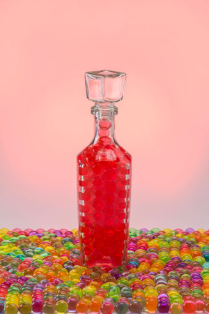 Carafe with A glass decanter with balls on a colored background and a light spotcolored ballsの写真素材