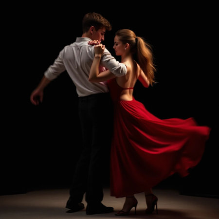 Young couple dancing tango in the studio on a black background.の素材