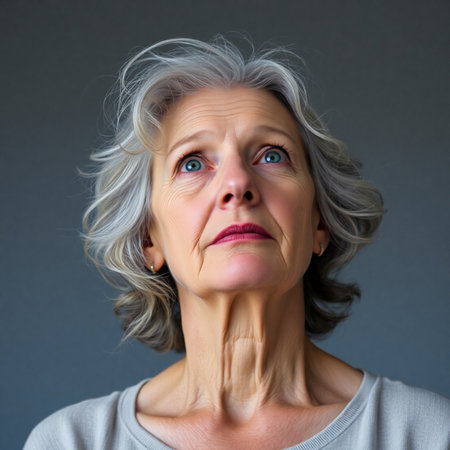 Portrait of a senior woman with gray hair on a gray backgroundの素材