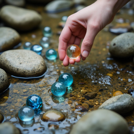 Hand of a child holding a crystal ball in a stream of waterの素材