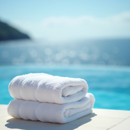 White towels on the edge of swimming pool with sea and sky backgroundの素材