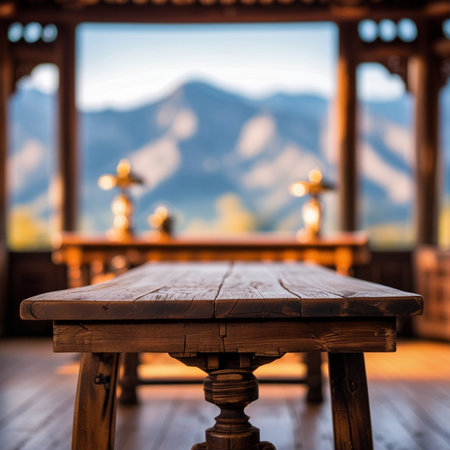 Wooden table in front of a window with mountains in the backgroundの素材
