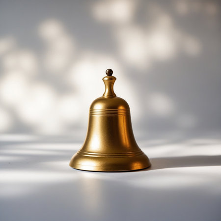 Bell with shadow on a white background. Selective focus, shallow depth of field.の素材