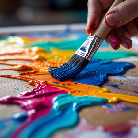Close-up of a woman's hand painting with a brush.の素材