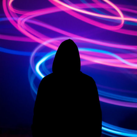 Silhouette of a hooded man in front of a colorful neon backgroundの素材