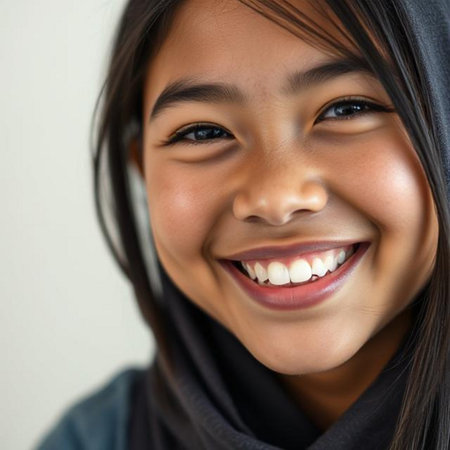 Portrait of a young Asian girl smiling with black headscarfの素材
