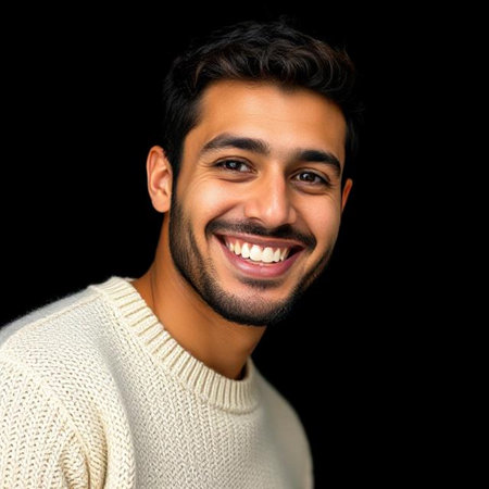 Portrait of a handsome young man smiling and looking at camera on black backgroundの素材