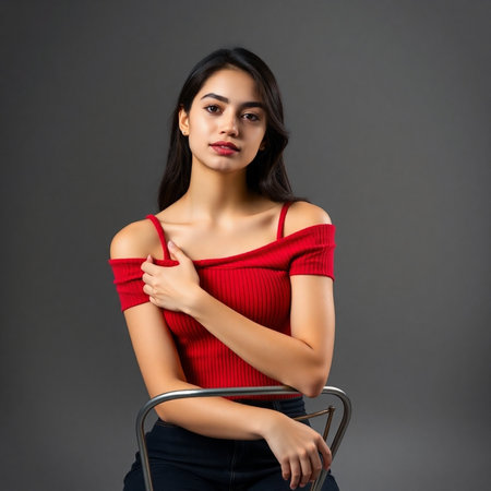 Portrait of a beautiful young woman in a red blouse on a gray backgroundの素材