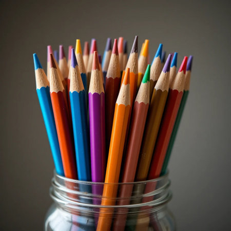 colored pencils in a glass jar on a gray background, close upの素材