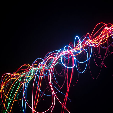 Colorful neon lines on a black background. Long exposure photo.の素材