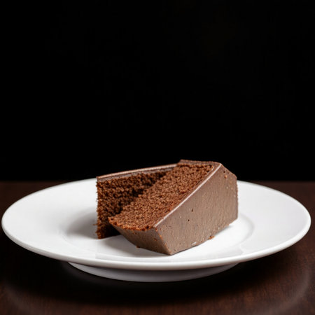 Chocolate cake on a white plate on a wooden table. Dark background.の素材