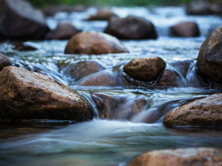 Close-up of water flowing over rocks in mountain creek. Selective focus.の素材