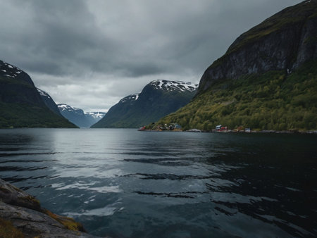 Norwegian fjord landscape with mountains and houses in cloudy weatherの素材