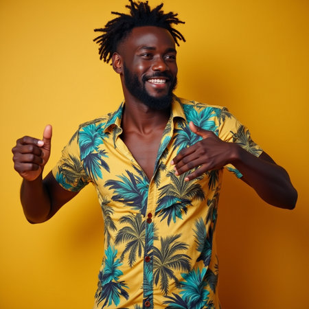 Cheerful african american man showing thumbs up on yellow backgroundの素材