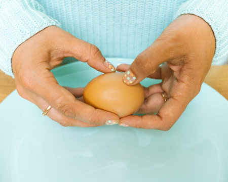 The hands of an unrecognizable woman peel a boiled eggの写真素材