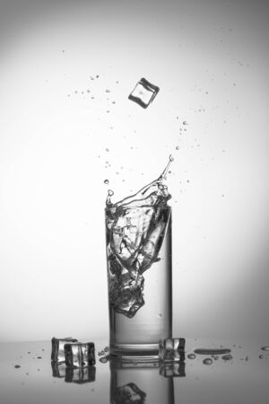 Water splash with ice in glass black and whiteの写真素材