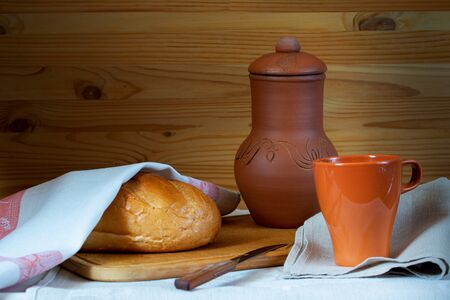 bread and milk jug with milk mug on a wooden backgroundの写真素材