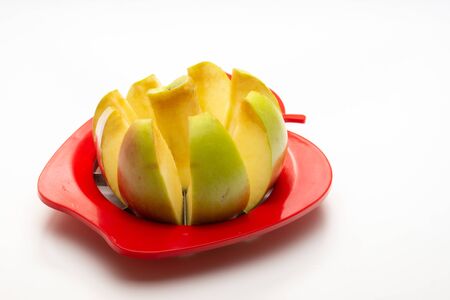 an Aan Apple partially cut with an Apple cutter on a white backgroundpple partially cut with an Apple cutter on a white backgroundの写真素材