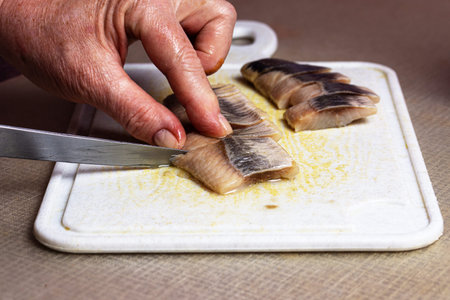 the process of cutting fillets of salted fish for making snacksの写真素材