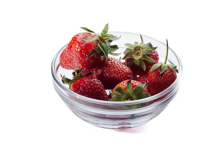 fresh red strawberries in a transparent salad bowl on a white backgroundの写真素材