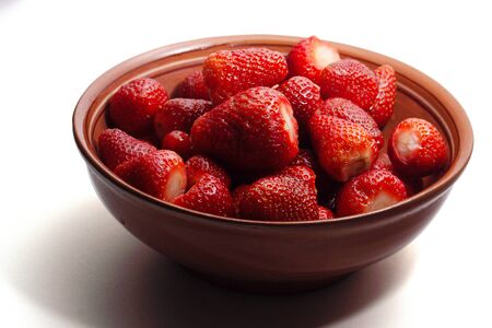 fresh red strawberries in a ceramic salad bowl on a white backgroundの写真素材