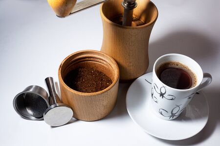 manual coffee grinder ground the filter press and a Cup of coffeeの写真素材