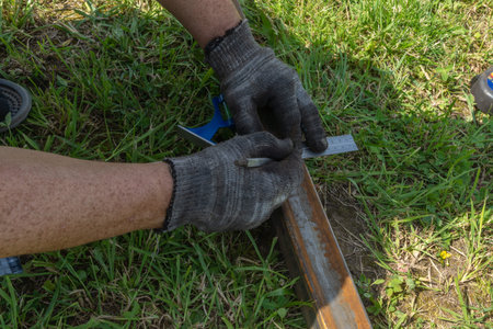 Male worker works with profile for drywall cuts it with metal
