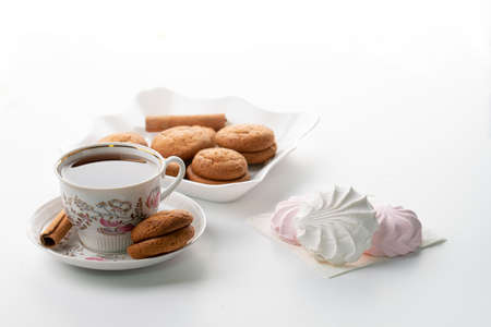 cup of tea marshmallow cookies cinnamon selective focus on white background high keyの写真素材