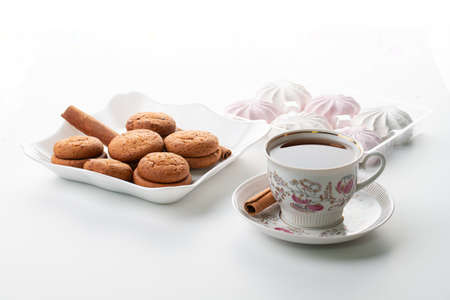 cup of tea marshmallow cookies cinnamon selective focus on white background high keyの写真素材