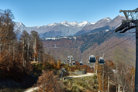 Snow-capped peaks of the Caucasus Mountains on the background blue sky, paraglider on the background of the valley, Krasnaya Polyana, travel conceptの写真素材