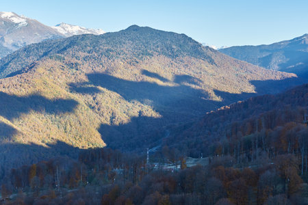 Snow-capped peaks of the Caucasus Mountains on the background blue sky, paraglider on the background of the valley, Krasnaya Polyana, travel conceptの写真素材