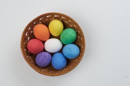 Easter Eggs in basketEaster colorful eggs in a basket on a white backgroundの写真素材