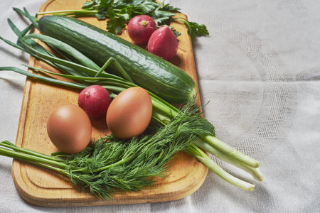 cucumber eggs onion parsley dill for making salad on a wooden stand selective focusの写真素材