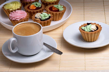 Morning aromatic coffee with colourful cupcakes with cream cakes on a white plate. Selective Focusの写真素材
