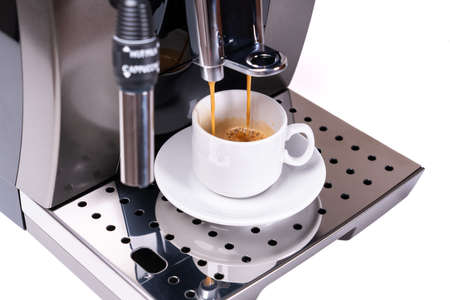 Coffee machine making fresh coffee with visible steam over cupの写真素材