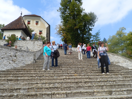 Tourists at stairways leading to a church located on an island in the middle of Bled lake, Sloveniaのeditorial素材