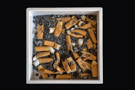 A white ashtray filled with cigarette buttsの写真素材